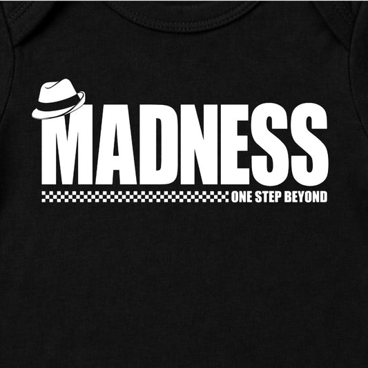Close Up Of Madness One Step Beyond Babygrow. White Madness Logo and One Step Beyond Artwork on a Black Babygrow